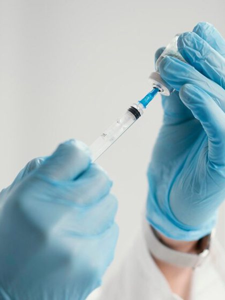 Personne tenant une aiguille pour une injection.