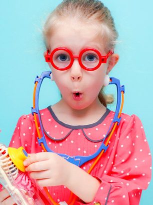 Petite fille myope jouant au docteur