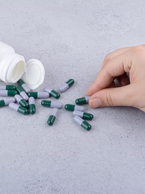 Photo d'une main prenant des pilules